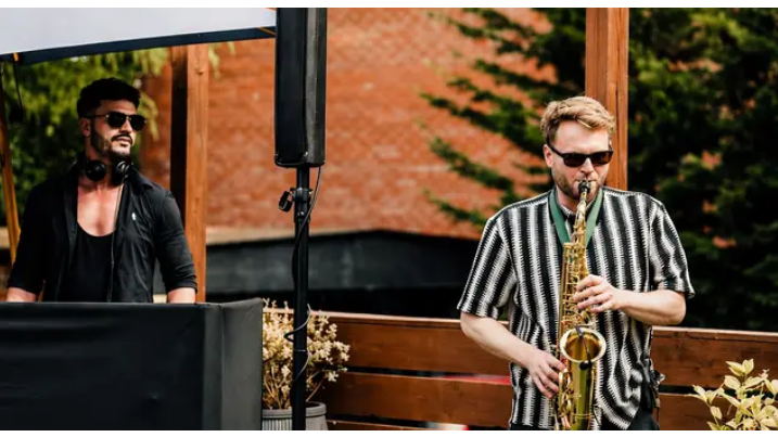 Ryan performing alongside a live saxophonist